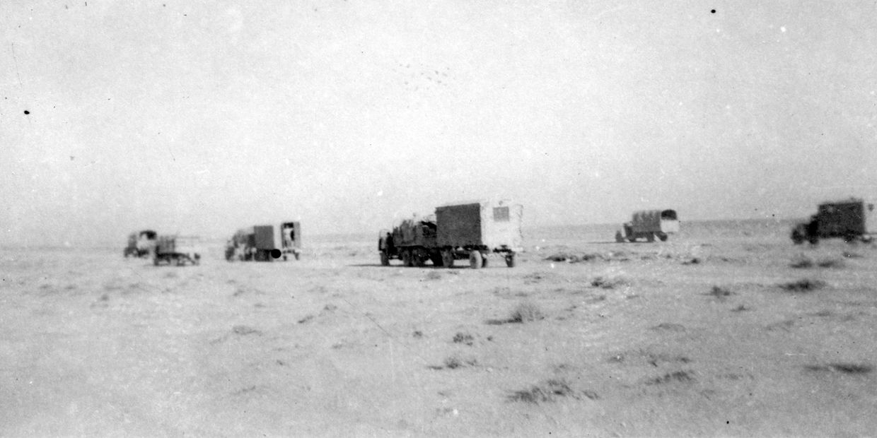 Military trucks in a desert landscape.