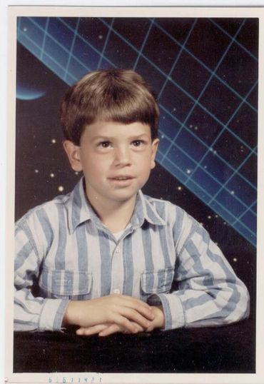 Young boy posing against blue grid.