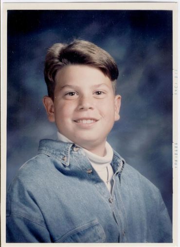 Young boy wearing a denim shirt.