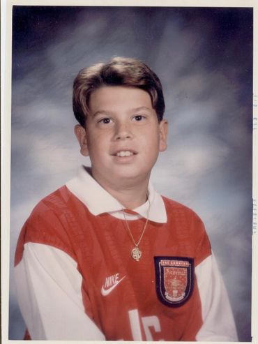 Boy wearing a red athletic jersey.