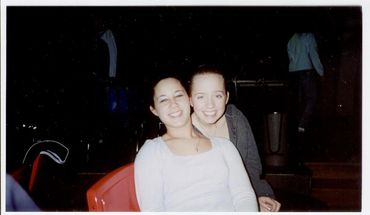 Two young women sitting together indoors.