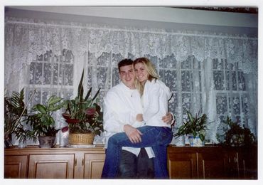 Couple posing in front of window.
