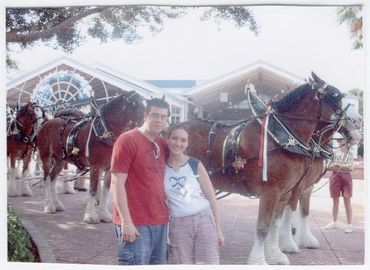 Couple standing by a horse carriage.