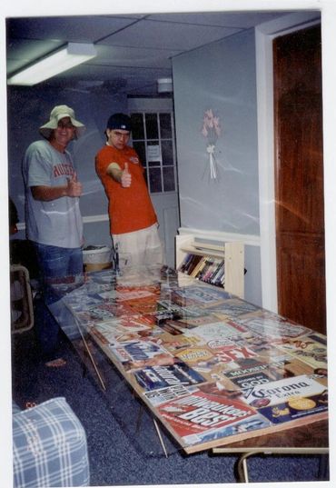 Two men standing by collage table.