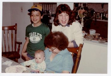 Family members smiling together in a kitchen.