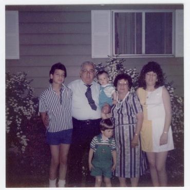 Multi-generational family portrait taken outdoors.