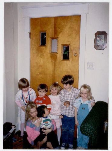 Group of children gathered by a door.