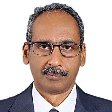 Professional headshot of a man wearing glasses and a suit.