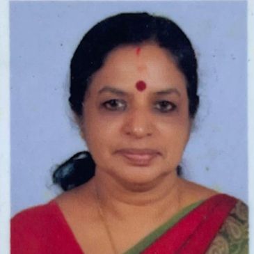 Portrait of a woman wearing a red saree with a bindi on her forehead.
