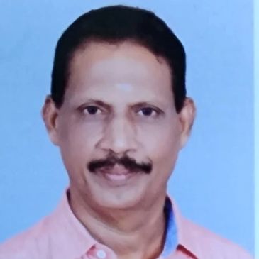 Portrait of a smiling man with a mustache wearing a pink shirt.