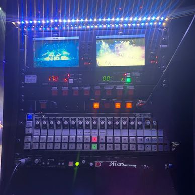 A professional video switcher with dual monitors and control buttons.