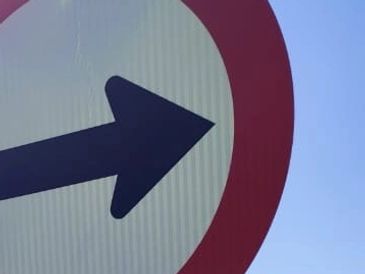 A close-up of a traffic sign with a right-pointing arrow.