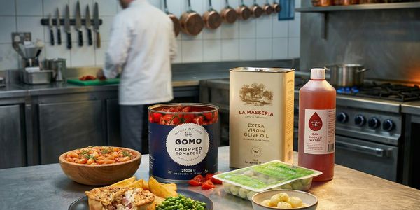 A kitchen counter with ingredients and a chef working in the background.