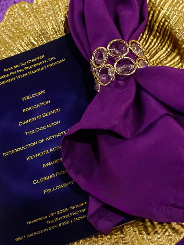 Elegant banquet setup with purple napkin and gold details.