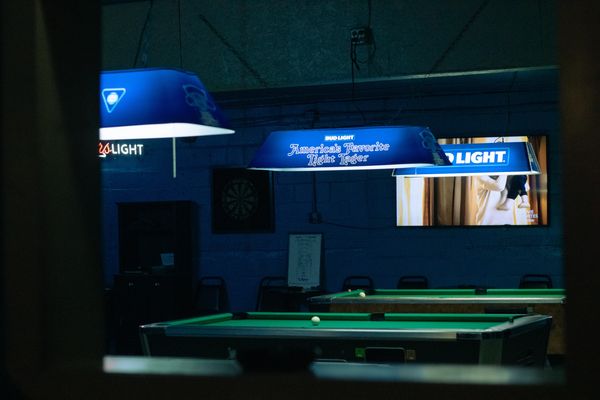 Billards tables with dive bar lighting featuring a dark hazy atmosphere.