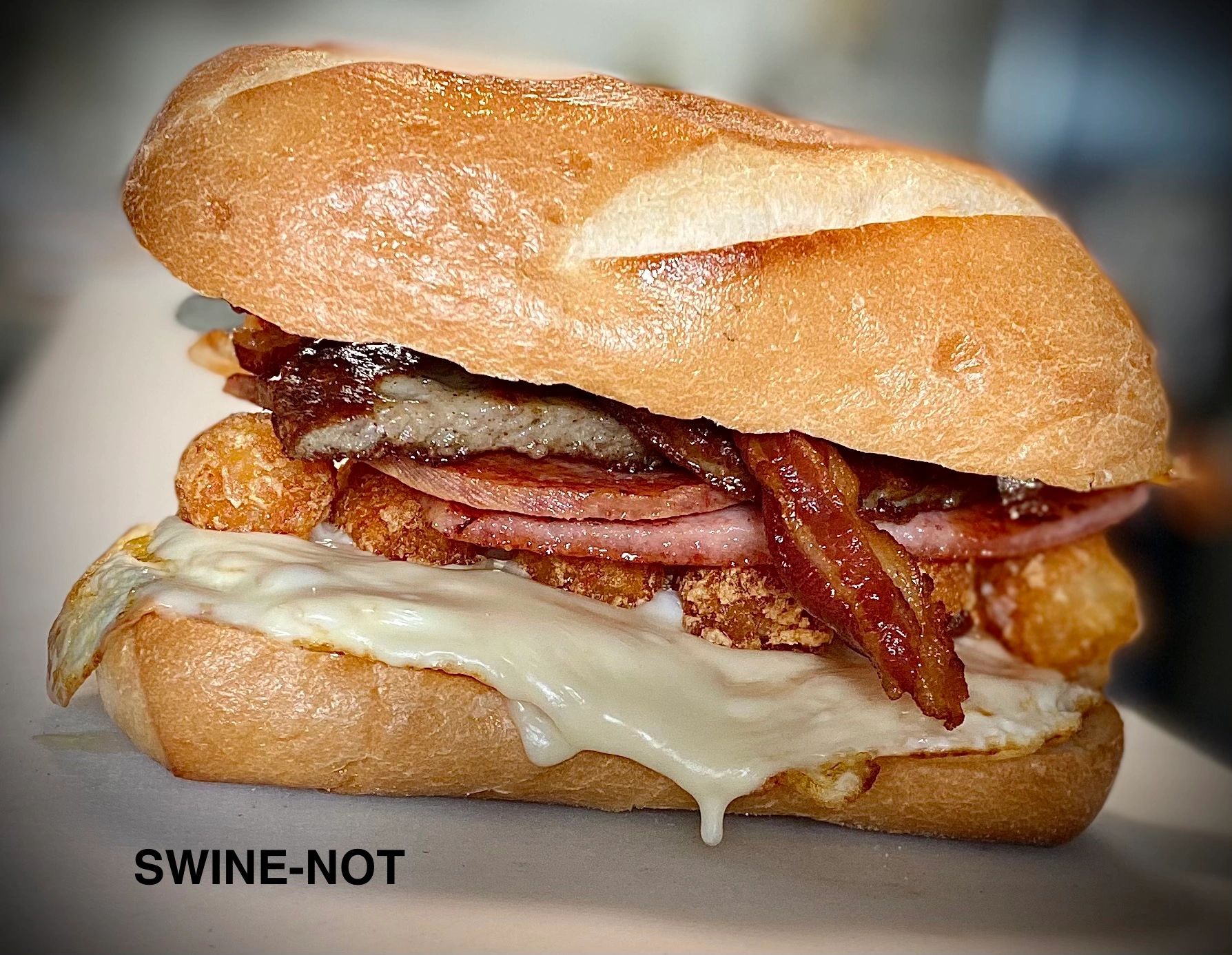 Swine-not sandwich with bacon, sausage, pork roll, tater tots, fried eggs and American cheese. 
