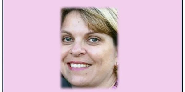 Smiling woman with light brown hair against a pink background.