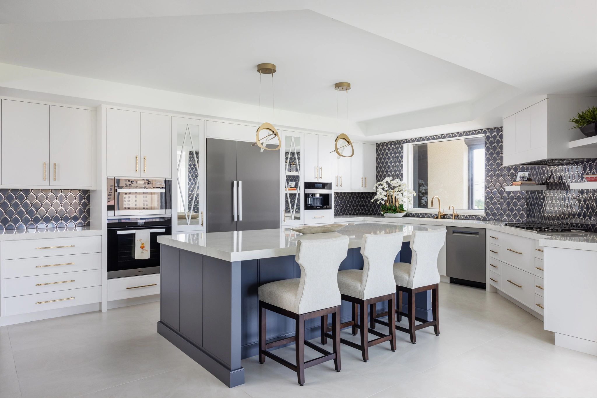 Modern kitchen with large island and decorative backsplash.