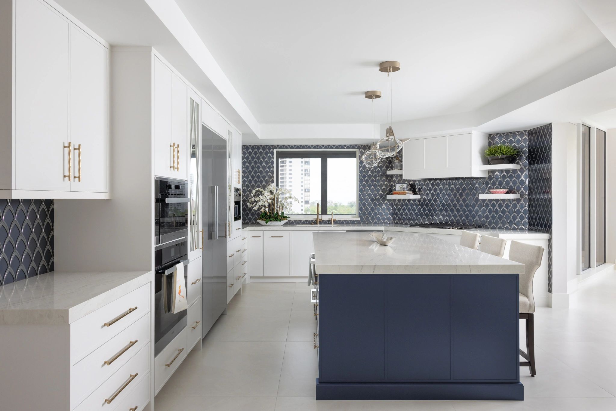 Modern kitchen with white and navy blue cabinetry and patterned backsplash.