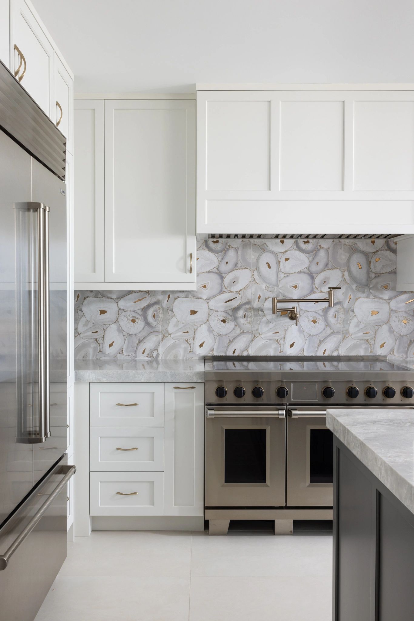 Modern kitchen with white cabinets and stainless steel appliances.