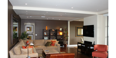 Modern living room with beige sectional sofa and orange accents.