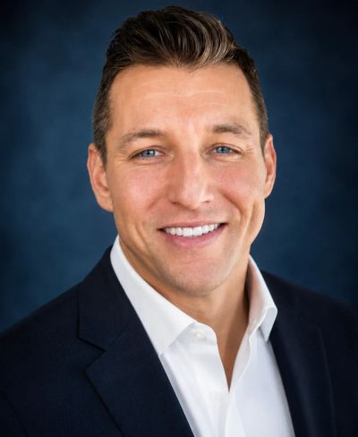 Smiling man in business attire with blue eyes.