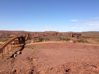Large mining site with conveyor belts and barren land.