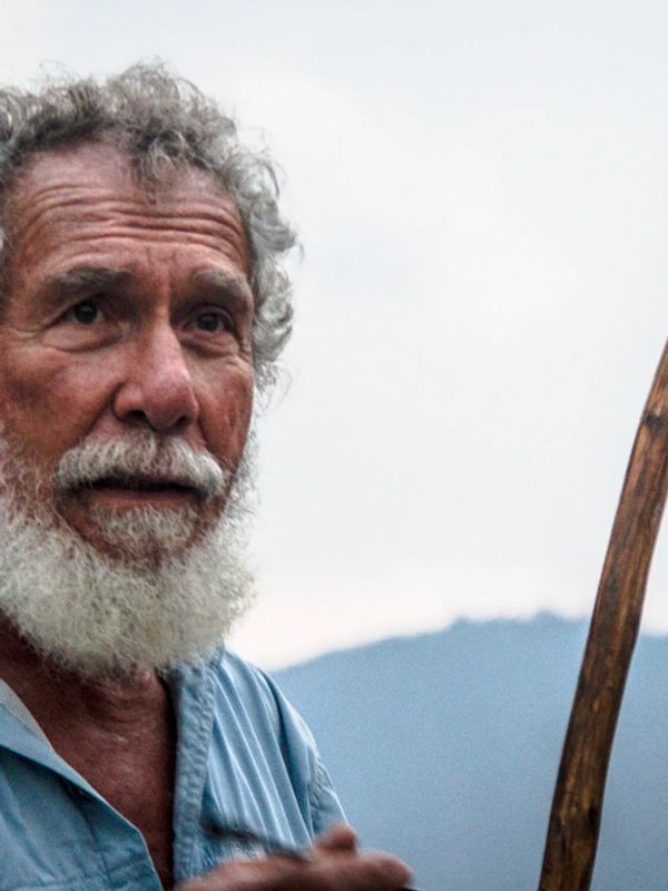 Portrait of an elderly man with a white beard outdoors.