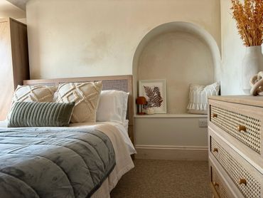 Cozy bedroom with neutral tones and textured decor.