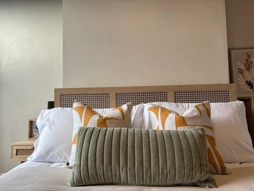 Comfortable bed with decorative pillows in a cozy bedroom.