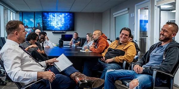 A group of people laughing and enjoying a meeting in a modern conference room.