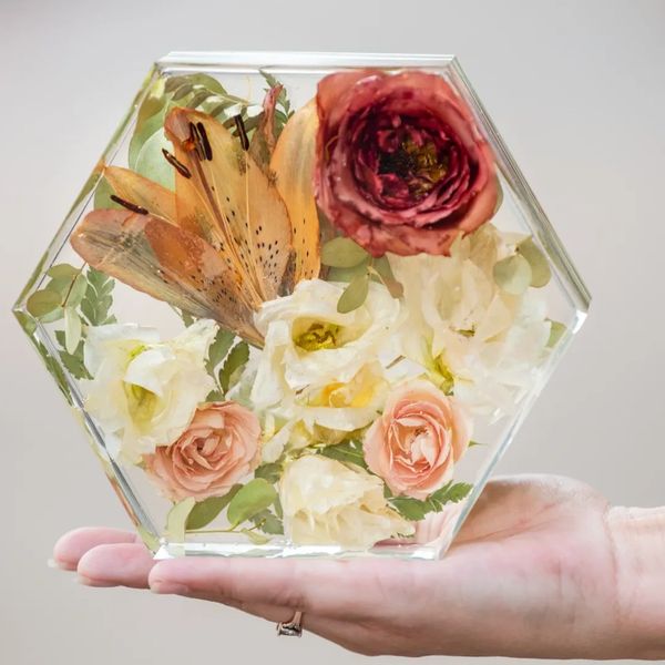 A person holding flowers stored in a Hexagon frame
