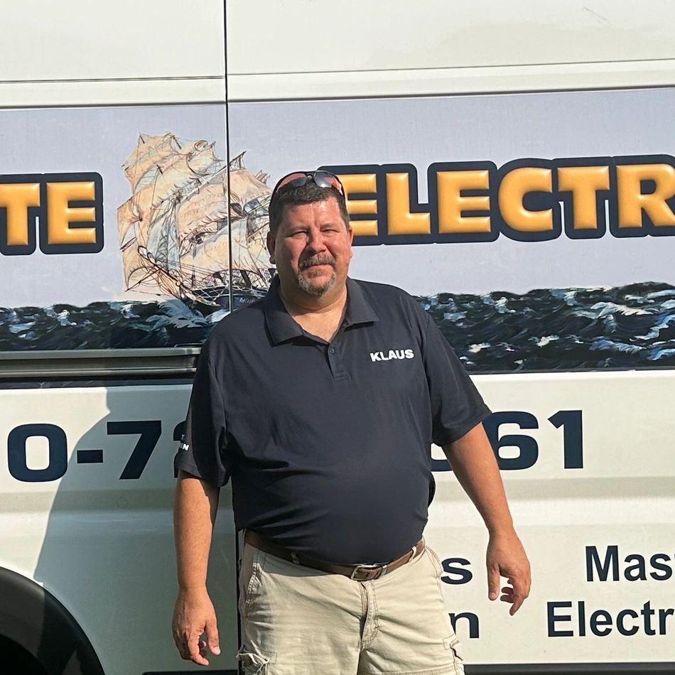 Man named Klaus standing in front of an electrical service vehicle.