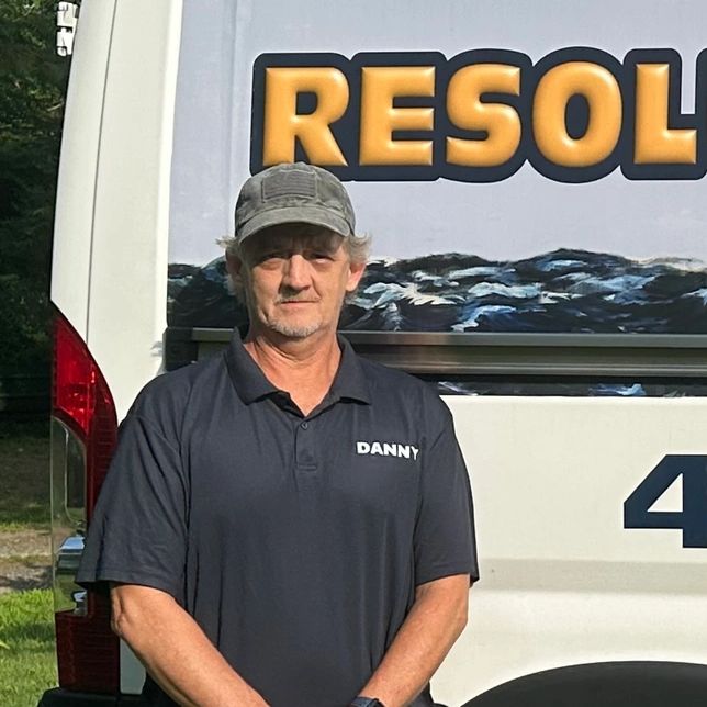 Man named Danny standing in front of a white van.