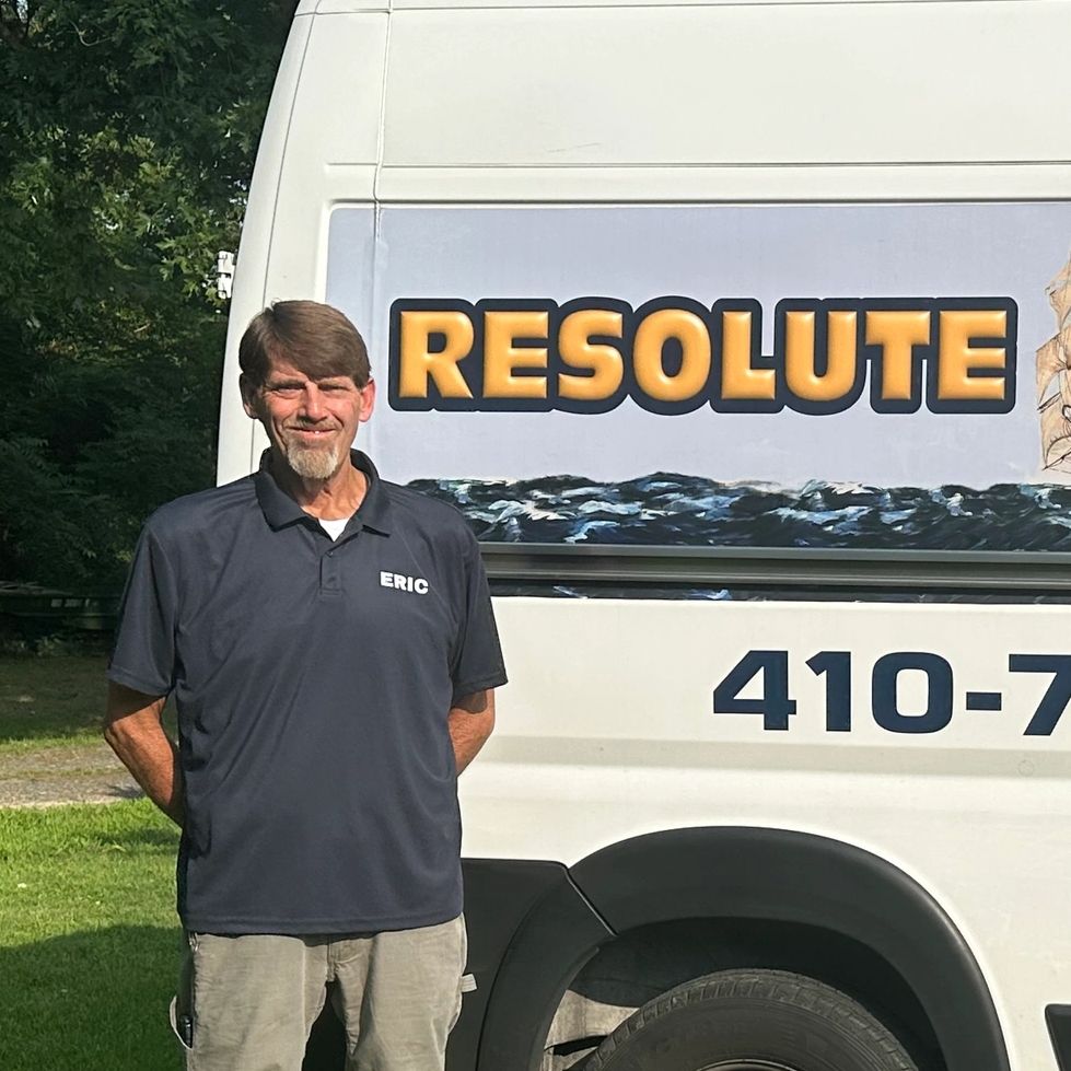 Man named Eric standing next to a van with 'RESOLUTE' text.