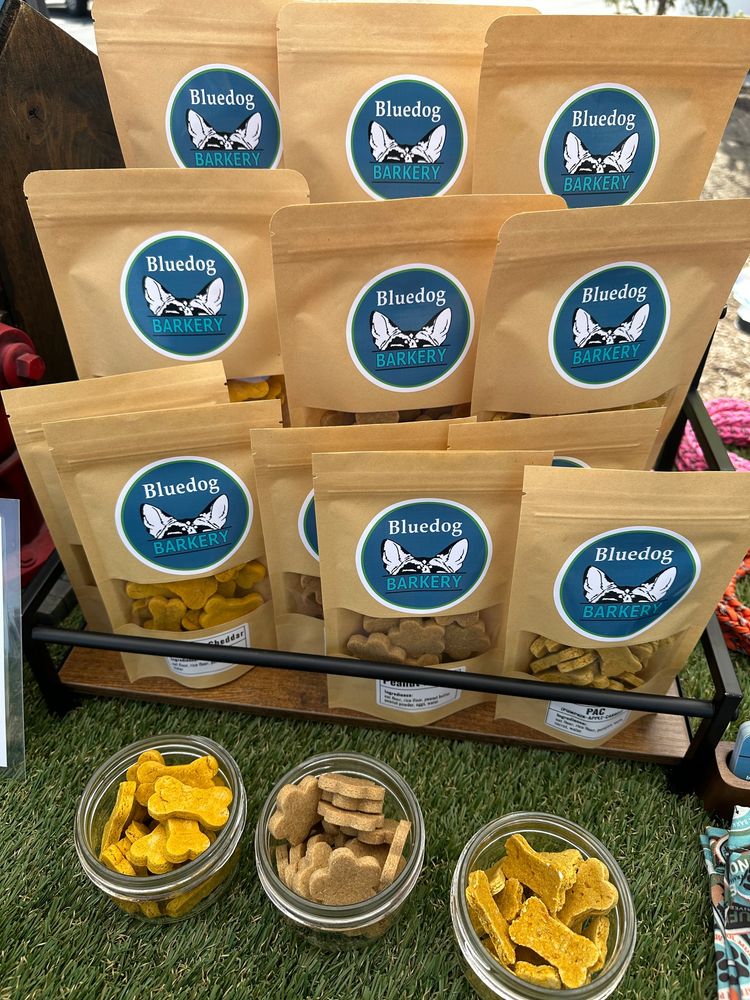 Bags of Bluedog Barkery Treats with jars of sample bones displayed in front.