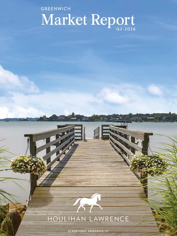 Wooden dock leading to calm water under a clear sky.