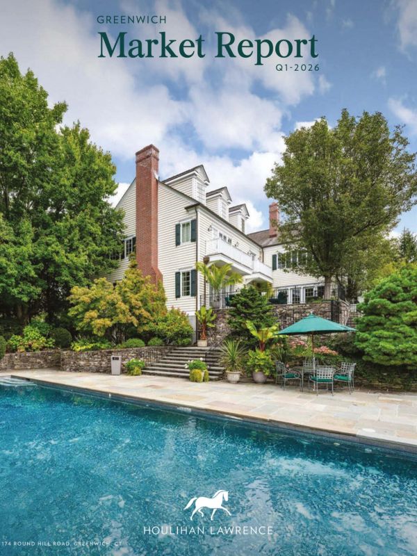 Large white house with a swimming pool and greenery.