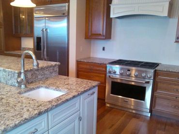 Speckled, neutral-colored granite countertop in a kitchen.