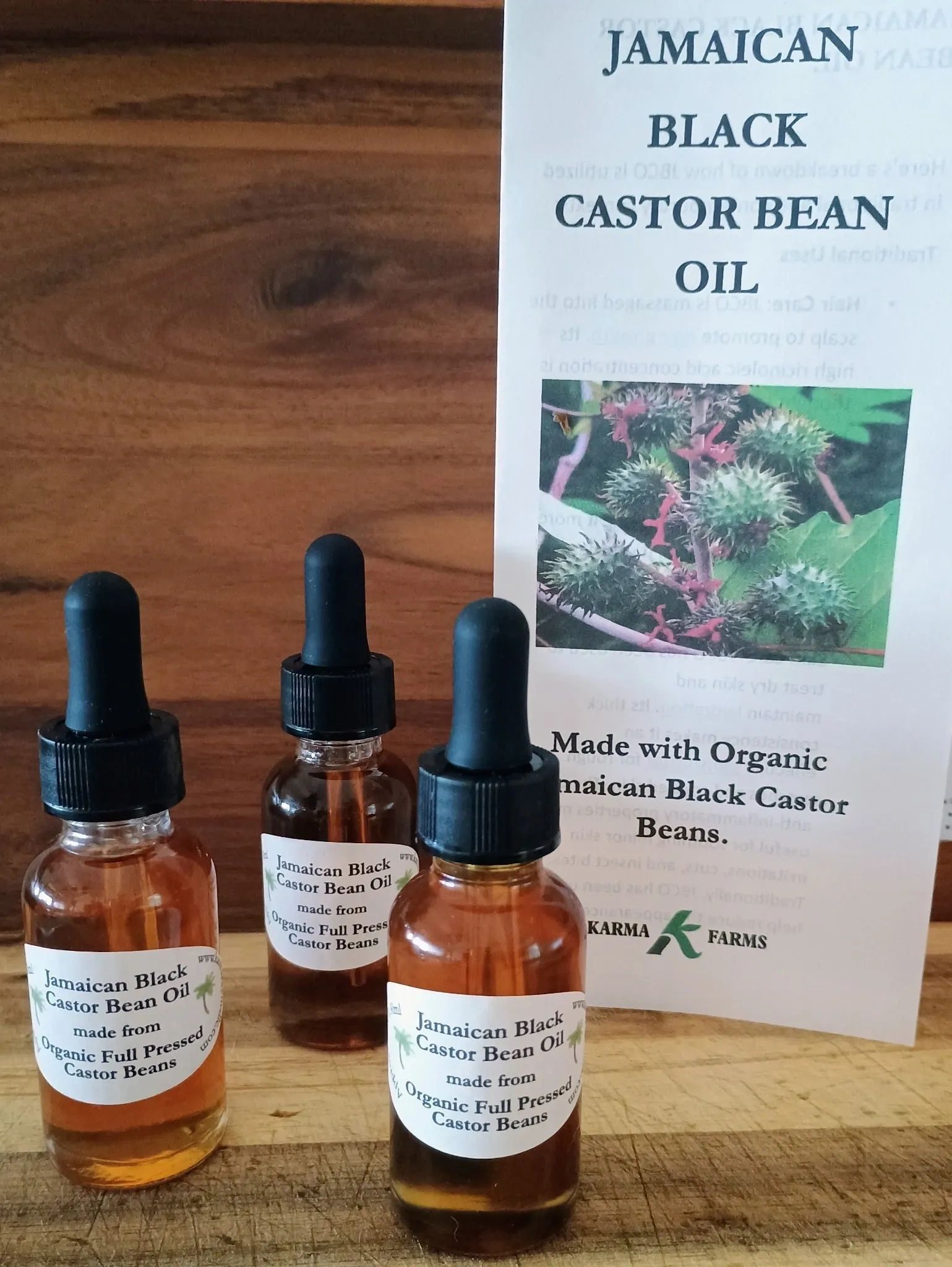 Bottles of Jamaican Black Castor Bean Oil on a wooden surface.
