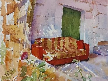 Watercolor painting of an old sofa against a stone wall.