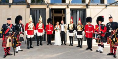 Wedding photo with ceremonial guards in traditional uniforms.