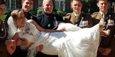 Bride being held by groomsmen in military uniforms.