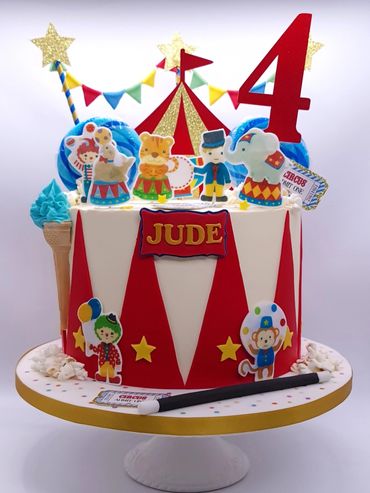 Circus-themed cake with wafer paper decorations. Circus tent and bunting. Blue lollipops & ice cream
