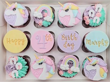 Chocolate cupcakes covered with chocolate buttercream and Unicorn themed fondant toppers