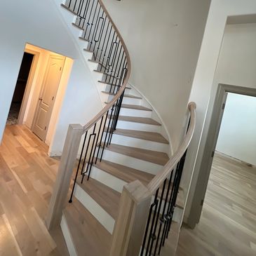 A staircase with metal railing and wood steps.