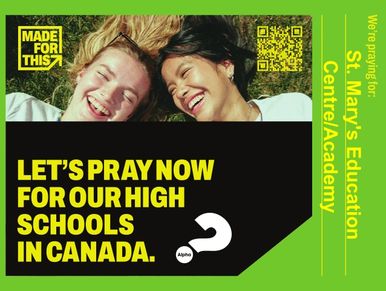 Two smiling girls lying on grass with a prayer message for Canadian high schools.