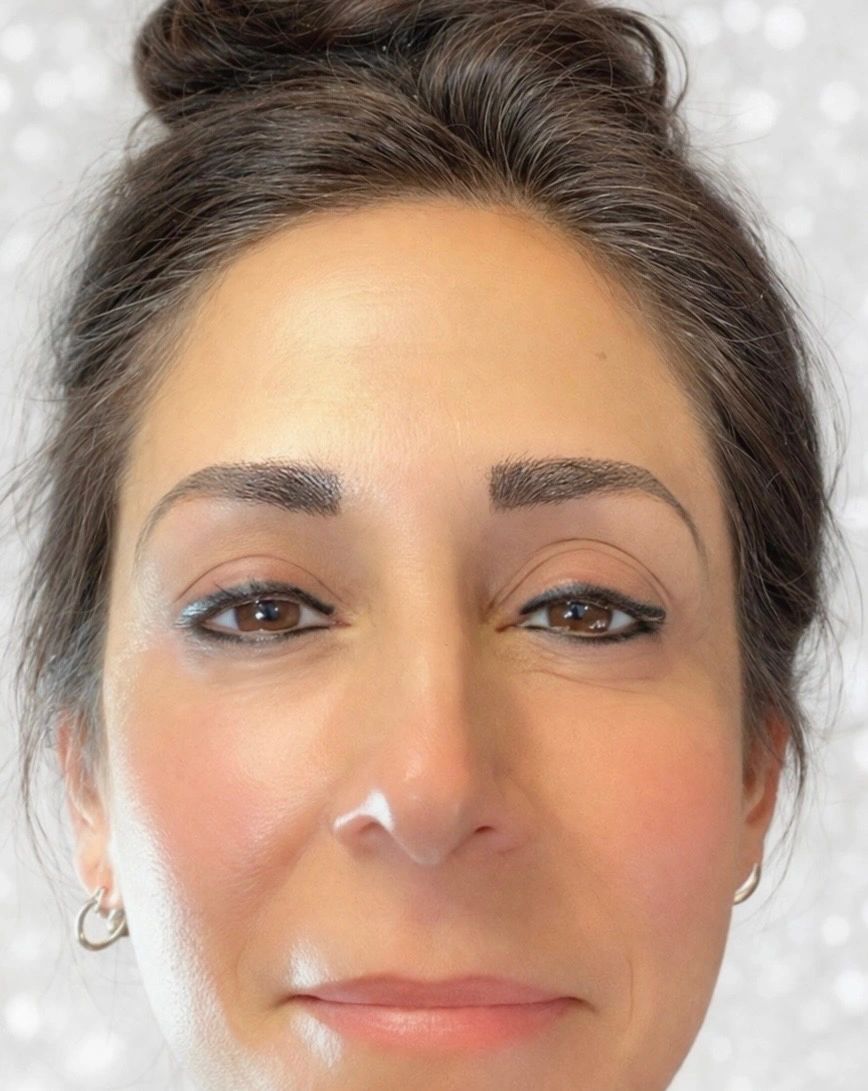 Close-up of a woman with natural makeup and hoop earrings.