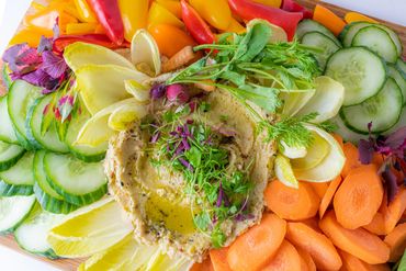 Vegetable board with brightly colored veggies and hummus.