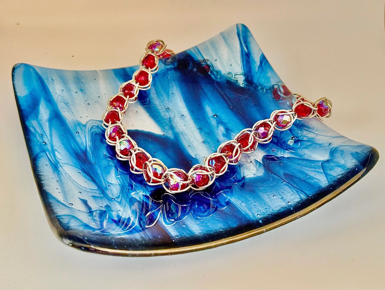 Blue glass plate with red beaded necklace